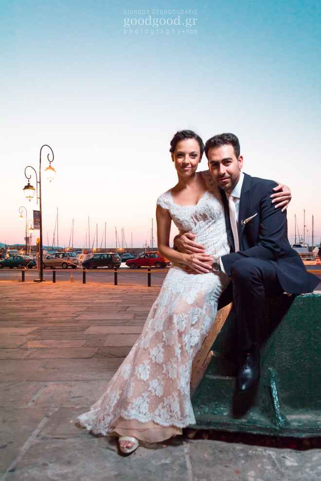 Photograph of a newly wed couple siting on a bollard at the Heraklion marina