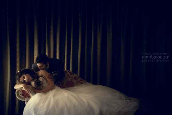 Bride laying in a daybed while the groom softly kisses her on the shoulder