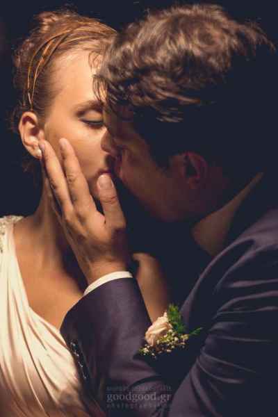 Photograph of a groom softly kissing the bride under an icelight