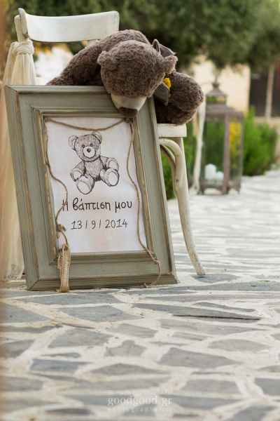 Λούτρινο αρκουδάκι κρέμεται επάνω σε μία πινακίδα καλωσορίσματος σε βάπτιση